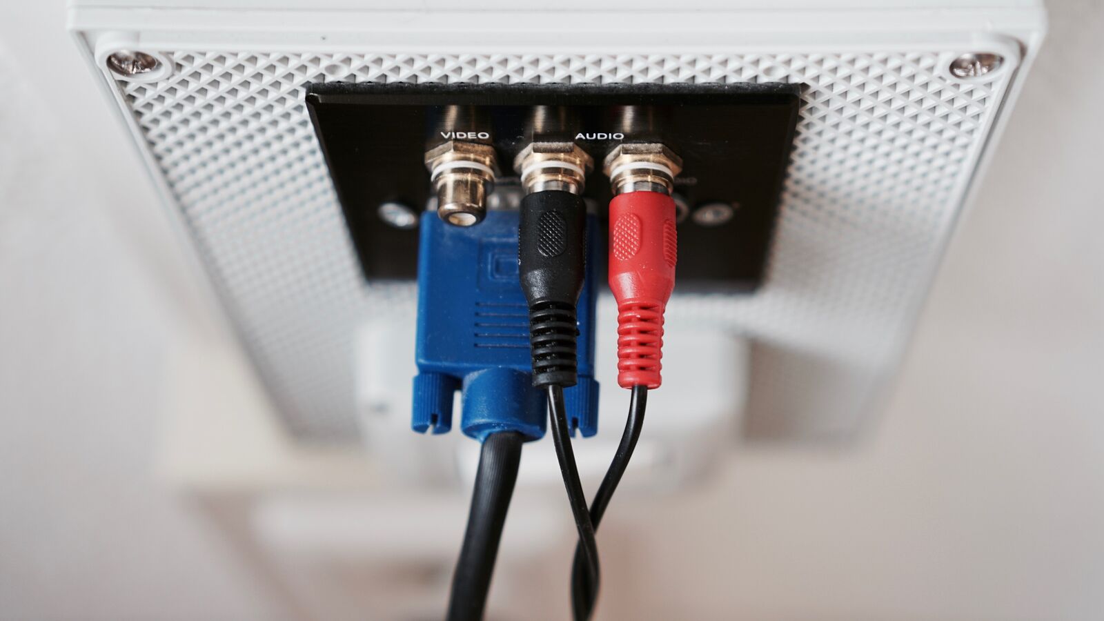 Video and audio connectors plugged into a white wall socket