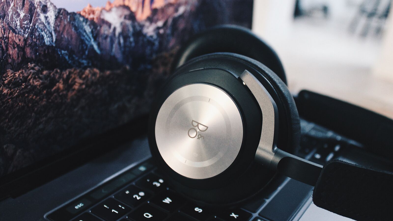 Over-ear headphones resting on a laptop keyboard